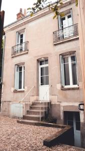 a building with stairs leading to a white door at L'Etape - La Maison des amis in Tours
