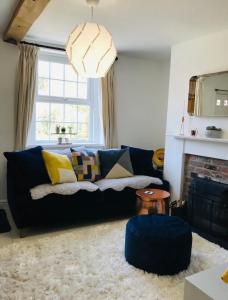- un salon avec un canapé bleu et une cheminée dans l'établissement Newly Renovated 5 Star Cosy-Up Romantic Cottage NEAR LONGLEAT, à Warminster