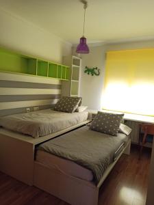 2 camas en una habitación con armarios verdes y amarillos en A la Vera de Alarcón, en Motilla del Palancar 10 fotos más