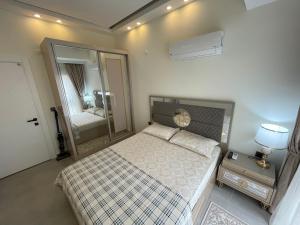 um pequeno quarto com uma cama e um espelho em SA Apartments! 1bd Flat 300m to the Beach em Alanya