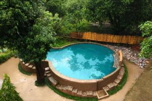 een uitzicht over een zwembad in een tuin bij Tashree Kabeela Riverside Resort in Marchula