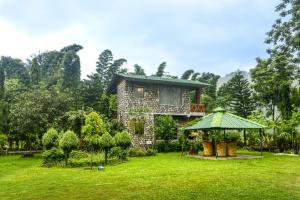 een huis in het midden van een tuin bij Tashree Kabeela Riverside Resort in Marchula
