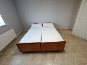 Schlafzimmer mit einem Bett mit weißer Bettwäsche und Holzböden in der Unterkunft Hotel Giurgiulesti 