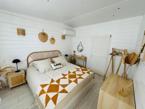a bedroom with a bed in a room with white walls at Cabane le Flamant avec jardin, piscine chauffée et parking in Saintes-Maries-de-la-Mer