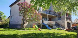 a house with a playground in front of it at Family Villa Sarapin in Kretinga