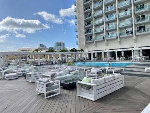 een zwembad met witte ligstoelen en een gebouw bij Ocean View Room at a resort in Honolulu