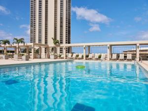 een groot zwembad voor een hoog gebouw bij Ocean View Room at a resort in Honolulu