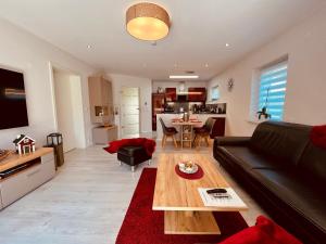 un soggiorno con un divano e un tavolo di Natur & Wellness Ferienhaus Garden a Siedlung Bergheide