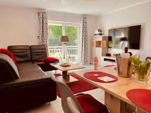 un soggiorno con un divano e un tavolo di Natur & Wellness Ferienhaus Garden a Siedlung Bergheide