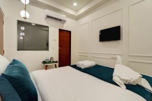 a bedroom with a bed and a flat screen tv at Hotel Aura Dombivali in Dive