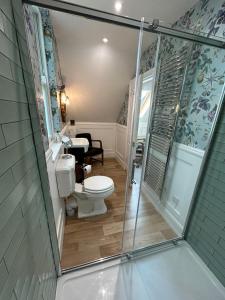 a bathroom with a toilet and a walk in shower at Ashleigh Buxton in Buxton