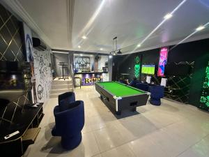 a living room with a pool table and some chairs at Port punta in Lekki