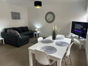 a living room with a white table and a couch at Bright, spacious and modern flat in Brentwood