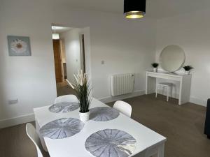 a dining room with a table and chairs with umbrellas on it at Bright, spacious and modern flat in Brentwood