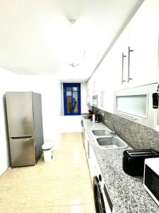 une cuisine avec un évier et un réfrigérateur dans l'établissement RelaxMaria, à Sant Carles de la Ràpita