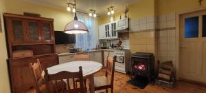 a kitchen with a table and a fire in a stove at Domek Drewniany in Nowa Wola