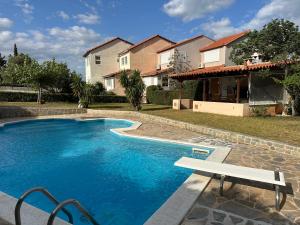 ein Pool mit einer Bank vor einem Haus in der Unterkunft Villa Sophia in Loutraki