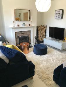 een woonkamer met een bank en een open haard bij Newly Renovated 5 Star Cosy-Up Romantic Cottage NEAR LONGLEAT in Warminster