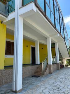 een uitzicht op een gebouw met gele muren en witte zuilen bij Tota apartments in Shkodër