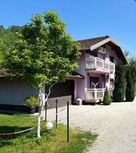 una casa rosa con un árbol delante en EMRAH RIVER UNA, en Bihać