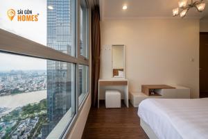 ein Hotelzimmer mit einem Bett und einem großen Fenster in der Unterkunft Vinhomes CenTral Park Saigon in Ho-Chi-Minh-Stadt