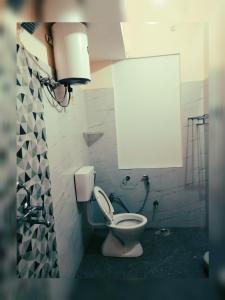 a bathroom with a white toilet in a room at Kashyaam Inn in Varanasi +10 photos
