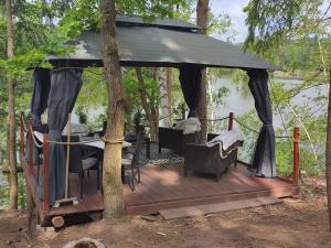 einen Pavillon mit einem Tisch und Stühlen auf einer Holzterrasse in der Unterkunft The Hideaway in Želiv