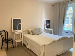 - une chambre avec un lit, une chaise et une fenêtre dans l'établissement PinkRose CityStay Järnvågen, à Göteborg