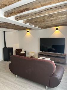 a living room with a couch and a flat screen tv at La p tite maison in Gien