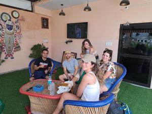 un grupo de personas sentadas alrededor de una mesa en Swaraj Palace, en Jaipur