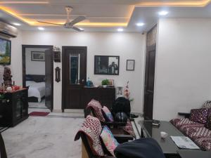 een woonkamer met banken en een plafondventilator bij YANA B&B in New Delhi