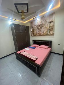 een slaapkamer met een bed met roze lakens erop bij Shah Guest House in Jhelum