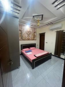 een slaapkamer met een roze bed in een kamer bij Shah Guest House in Jhelum