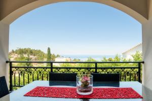a table on the balcony with a view of the ocean at Villa Maria in Roussospítion
