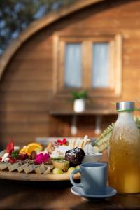 Amani Suite con Jacuzzi piscina y naturaleza في Buzanada: طبق من الطعام على طاولة مع كوب من العصير