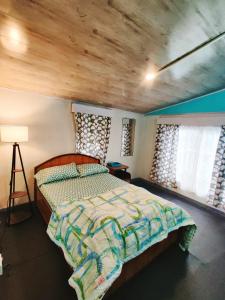 1 dormitorio con 1 cama con techo de madera en New Sangam Homestay, en Darjeeling