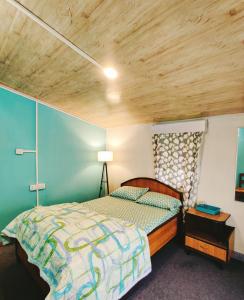 1 dormitorio con cama y techo de madera en New Sangam Homestay, en Darjeeling