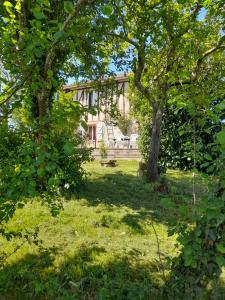 ein Haus inmitten eines Gartens mit Bäumen in der Unterkunft Maison dans le sud du Gers 