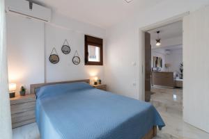 ニキティにあるSithonia RS Olive Luxury Maisonetteの白いベッドルーム(青いベッド1台付)、バスルームが備わります。