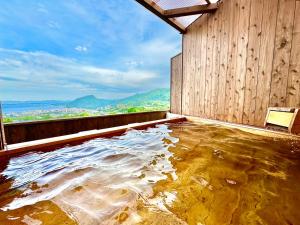 um quarto com uma grande piscina de água no chão em Resort Stay Spa Tsurumi em Beppu