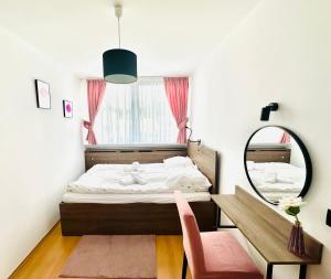 Schlafzimmer mit einem Bett, einem Spiegel und einem Schreibtisch in der Unterkunft Roma in Duszniki-Zdrój