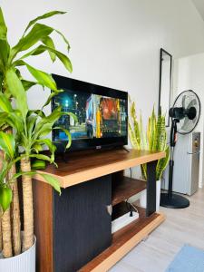 a flat screen tv sitting on top of a wooden table at Vinia Infinity Studio 1 Near Malls with WiFi and Netflix in Manila +18 photos