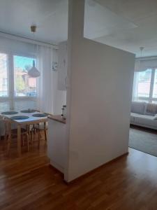 a kitchen and living room with a table and a kitchen and a dining room at Bright apartment, airport 3km, private parking, sauna in Vantaa