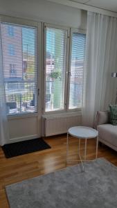 a living room with a table and two windows at Bright apartment, airport 3km, private parking, sauna in Vantaa