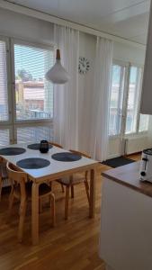 a living room with a table and some windows at Bright apartment, airport 3km, private parking, sauna in Vantaa