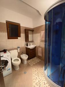 a bathroom with a toilet and a sink and a shower at Cozy Corner - Apartment in Korça in Korçë
