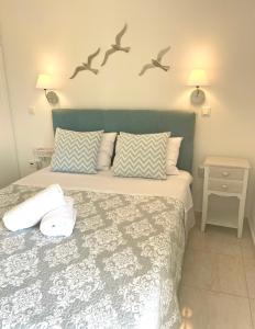 um quarto com uma cama com pássaros na parede em Aqua Seaview Suite em Barbati