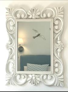 um espelho com uma moldura branca numa parede em Aqua Seaview Suite em Barbati