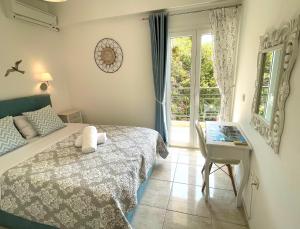 um quarto com uma cama, uma secretária e uma janela em Aqua Seaview Suite em Barbati