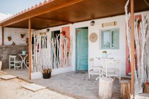 un patio con una puerta azul y una mesa en Macaronesia Love Spa, sauna y piscina en Buzanada